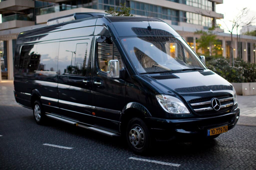 Black Mercedes-Benz Sprinter on an urban street at dusk